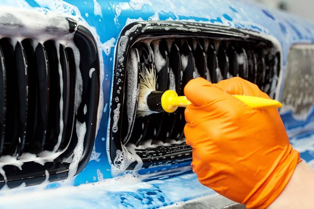 Hand car wash service in Swindon with a technician meticulously cleaning a car's exterior to ensure a spotless and well-maintained finish