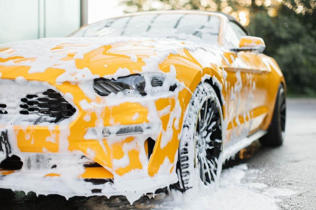 Using the two bucket washing method to clean a car in Swindon, ensuring a scratch-free and thorough wash